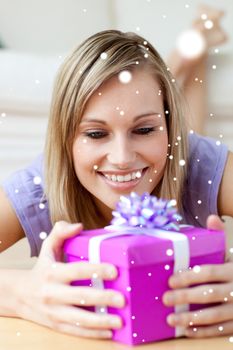 Composite image of jolly woman holding a gift 