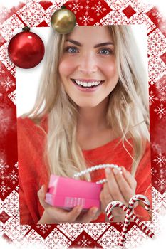 Composite image of cheerful woman discovering necklace in a gift box