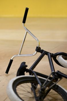 Black BMX Bicycle Lying on the Floor in the Bike and Skatepark Indoor. Healthy and Active Lifestyle Concept.