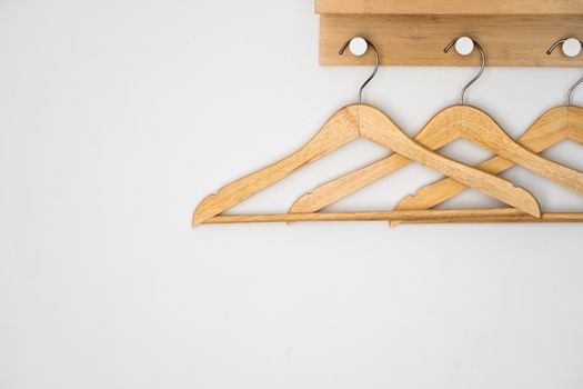 Clothes wooden hangers on a white wall.