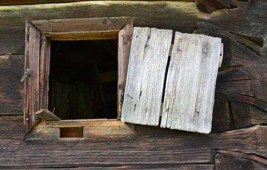 Open window of an old house built of round logs