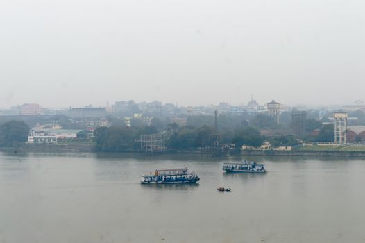 Panoramic Kolkata riverside city life in a winner foggy evening. Ariel view Kolkata in Hooghly riverbank West Bengal India South Asia Pacific. Photography from rooftop.
