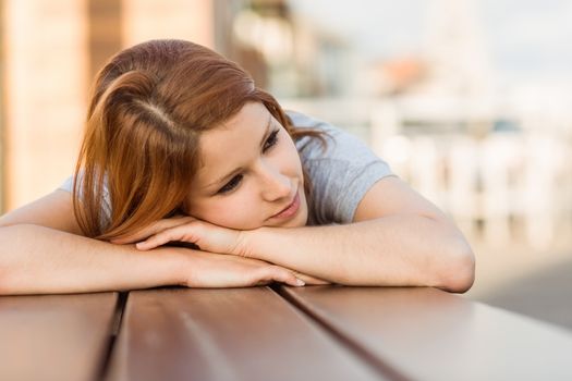 Day dreaming casual redhead lying on bench
