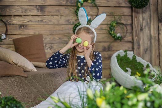 Portrait of girl having fun on Easter wearing bunny ears and hol