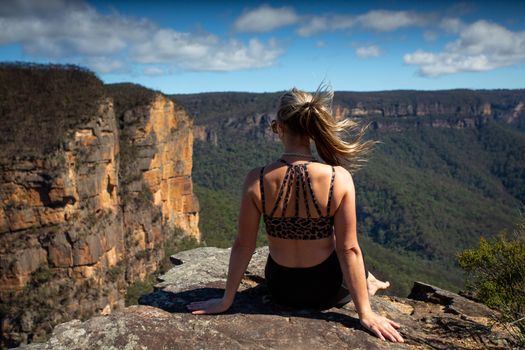 Woman relaxing on a cliff with scenic views
