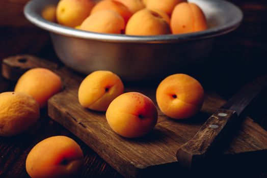 Mellow apricots with knife over cutting board