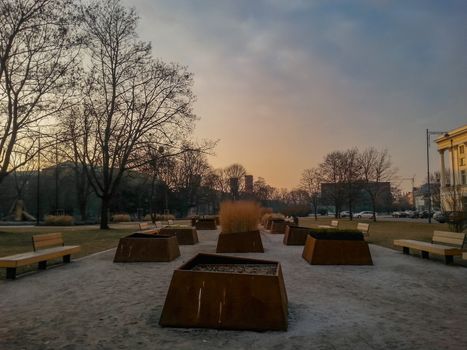 Huge flowerpots and benches around in boulevard at sunset in Wroclaw