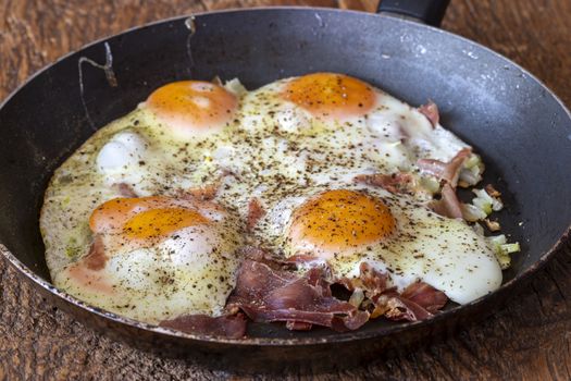 four fried eggs in a pan