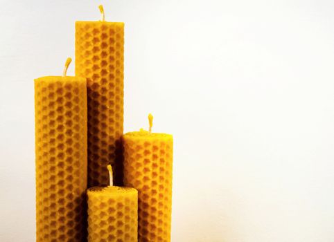 four beeswax candles on a white background