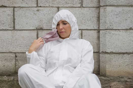 Woman in pink mask and white protective suit outdoors
