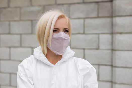 Woman in black mask and white protective suit outdoors