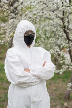 Woman in black mask and white protective suit inspring