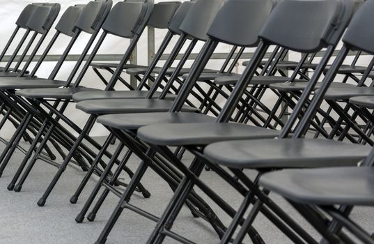 numerous folding chairs arranged in a row