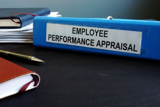 Folder with employee performance appraisal on the desk.