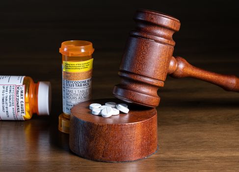 Oxycodone opioid tablets with judge gavel for court decision about liability