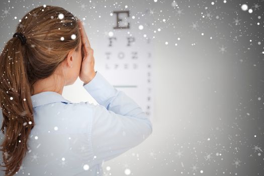 Composite image of brunette woman making an eye test 