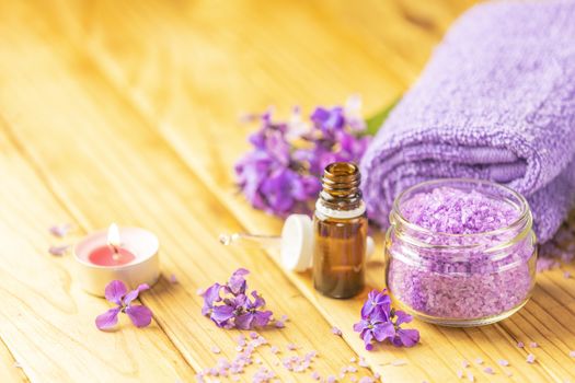 Spa still life with violet oil, towel, violaceous bath salt