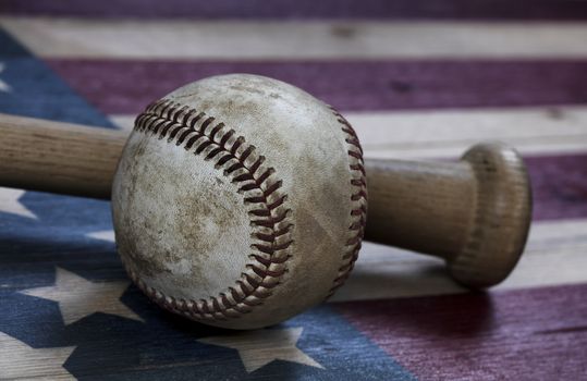 Closeup view of a used baseball and traditional wood bat on rust