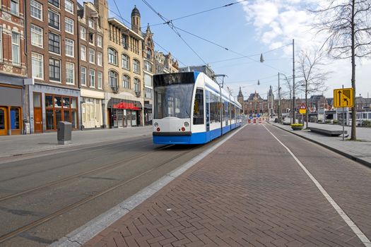 Tram driving on an empty Rokin in Amsterdam the Netherlands duri