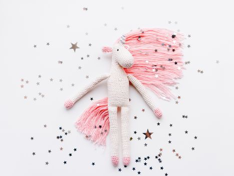 Cute fairy unicorn with a pink mane and a tail made of threads. 