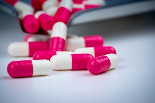 Pink-white capsule pills on stainless steel drug tray. Pharmacy 
