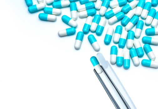 Forceps pick white-blue capsule from group of capsule pills. Dru
