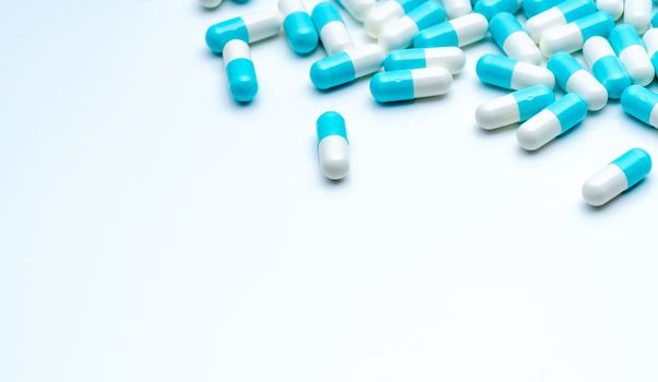 Blue-white capsule pills spread on white background with copy sp