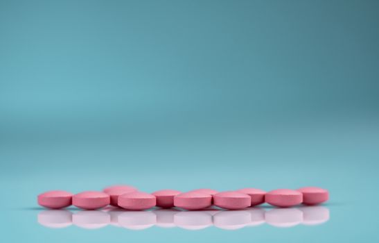 Round pink tablets pill on gradient background. Vitamins and min