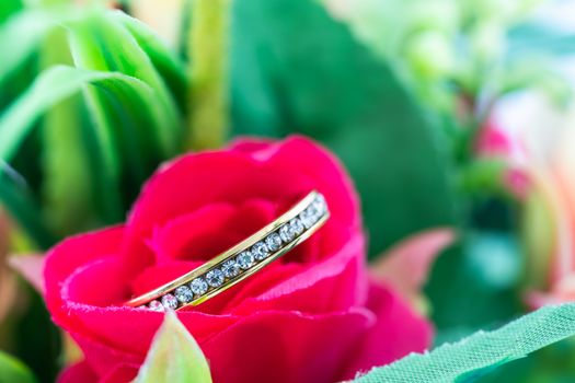 Wedding ring resting in a fake rose flower