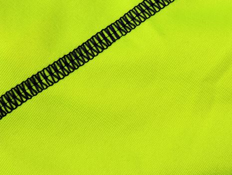 Black seam on green textile detail (diagonal)
