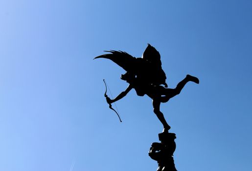 LONDON, UK - AUGUST 2018: Eros statue with bow and arrow against blue sky in Piccadilly Circus