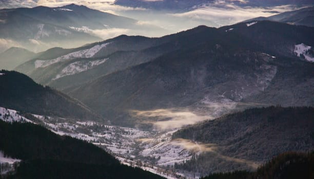 Misty morning on valley, winter landscape from mountain top
