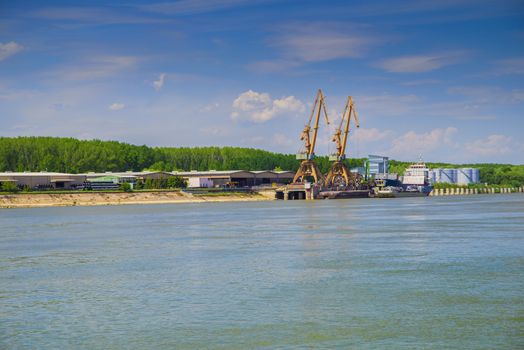 Shipyard with cranes on Danube river in a sunny summer day