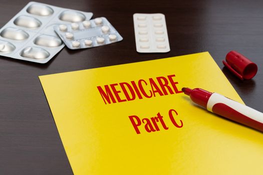 Medicare Part C, the text is written in red letters on a yellow sheet. An alternative way to get your Medicare benefits.