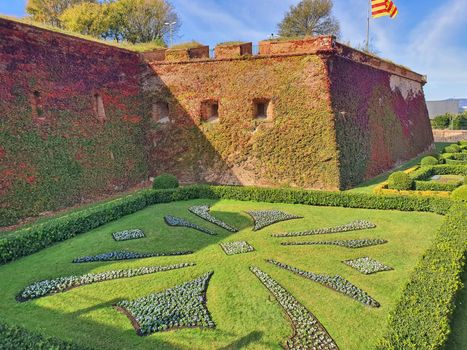 Green yard and ancient fortification, Montjuic Castle, well known landmark in Barcelona.