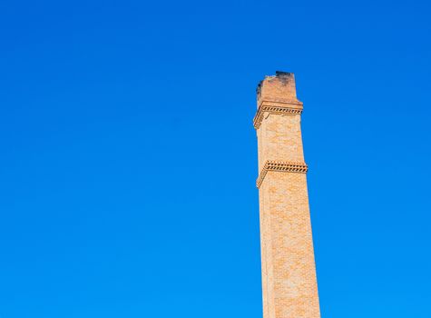 Old brick chimney on the background of clear  blue sky