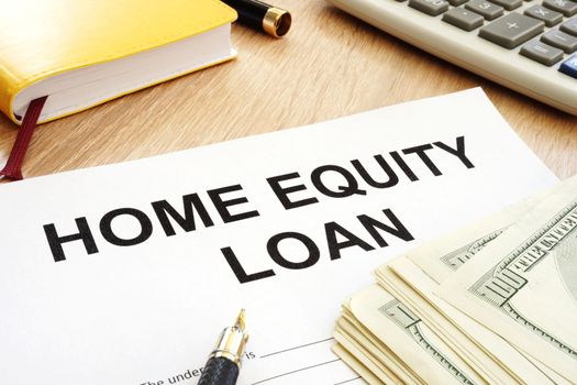 Home equity loan form and cash on a table.