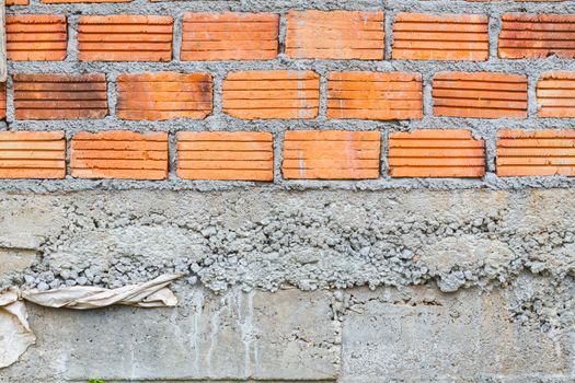closeup orange horizontal textured brick with dry concrete stain