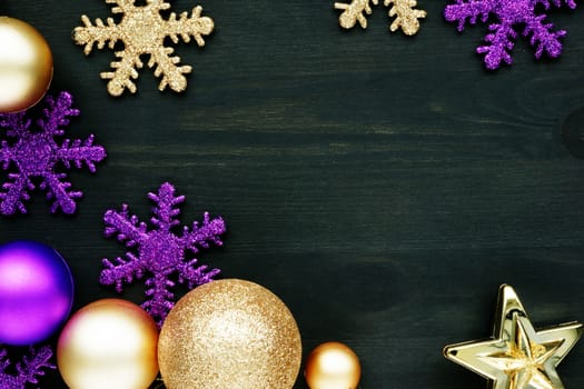 Christmas decoration balls and snowflakes on a dark wooden background with free space.