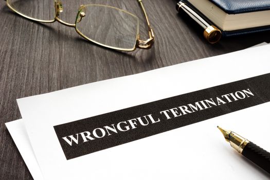Documents about Wrongful termination on a wooden desk.