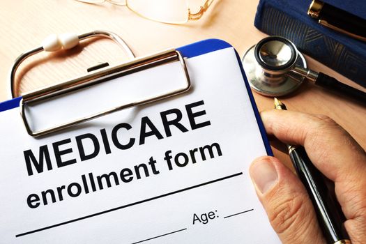 Medicare enrollment form in a hand.