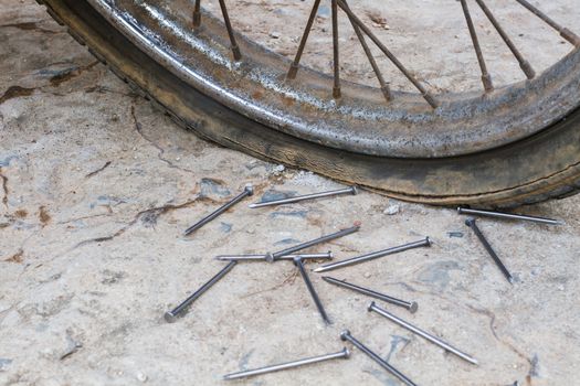 big nails and old flat wheel of motorcycle