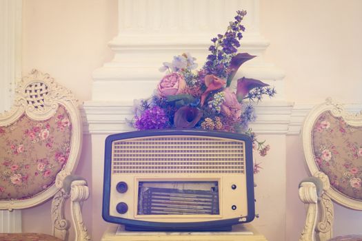 antique radio with flower and chairs on vintage background