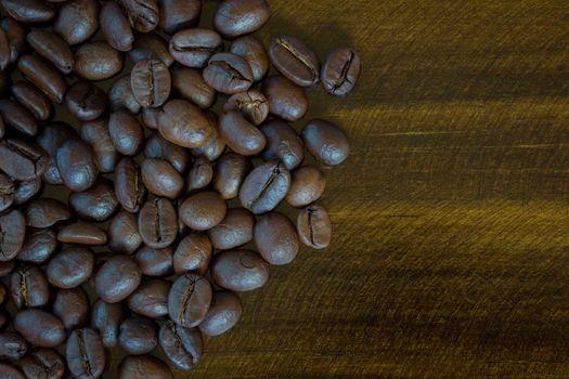 extreme closeup coffee beans on wooden background, dark tone. To