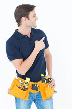 Man with tool belt around waist pointing against white background