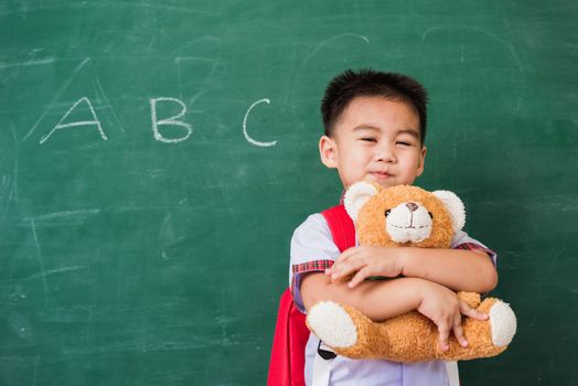 Child boy from kindergarten in student uniform with school bag s