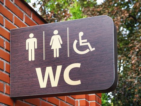 Public toilet. Sign for man, woman, disabled person and the letters WC.