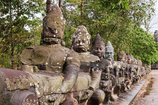 Stone sculptures near South Gate of Angkor Thom from outside the city. Angkor Wat. Siem Reap, Cambodia. UNESCO World Heritage Site.