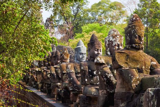 Stone sculptures near South Gate of Angkor Thom from outside the city. Angkor Wat. Siem Reap, Cambodia. UNESCO World Heritage Site.