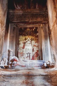 Room with scented candles, Buddha sculpture and sacral decorations in Angkor Wat, temple complex in Cambodia and the largest religious monument in the world. UNESCO World Heritage Site.